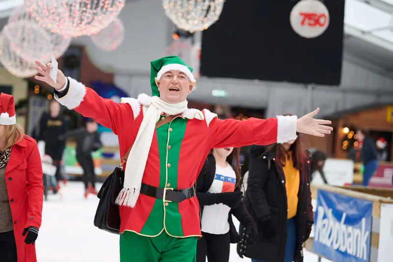 Świąteczny elf rozkłada ręce na lodzie